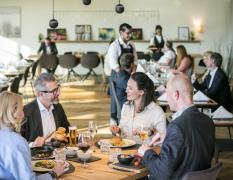 ARCOTEL Nike Linz Gäste genießen das Abendessen mit schön gedeckten Tischen im ARCOTEL Nike Linz