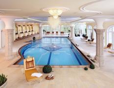 Der Lärchenhof Innenpool mit Liegen, Säulen und großen Fenstern im Hotel Der Lärchenhof