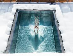 Beheizter Aussenpool im Winter mit einem Gast im Hotel Klausnerhof