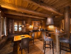Küche und Wohnbereich in einem rustikalen Chalet im Chaletdorf Auszeit ganz in Holzoptik gehalten