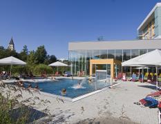 Blick auf den Aussenpool und die Kirche im Hintergrund des Gesundheitsresorts Lebensquell Bad Zell