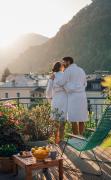 Ein Paar im Bademantel auf der Terrasse des Hotels und Villa Auersperg Salzburg stehend und sich küssend